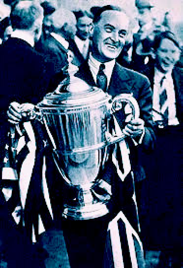 Malcolm Campbell holding a large winners cup