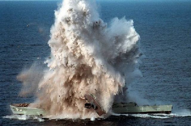 Navy target ship is struck by a torpedo, breaking its back