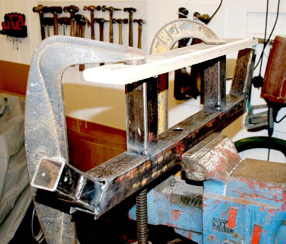 Tack welding the robot frame, clamped in a vice