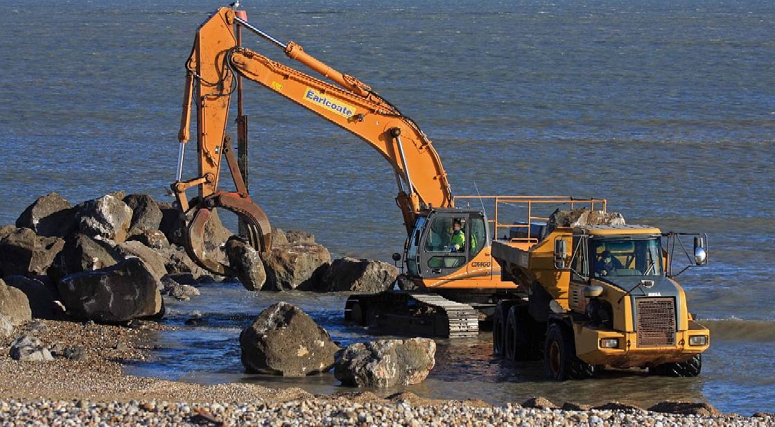 Large rocks are positioned to absorb wave impacts