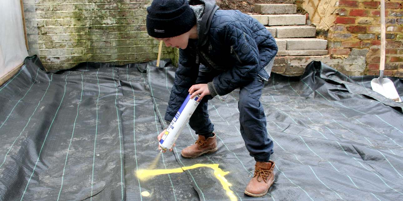 Ryan marks out a drain using line marking paint