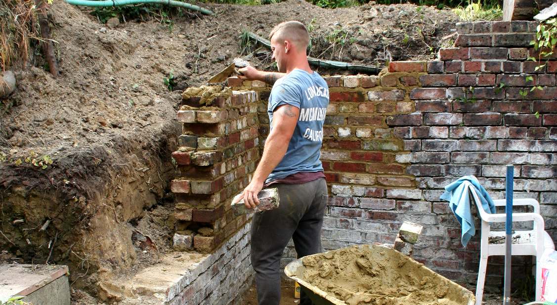 Our master builder lays original recycled bricks to repair the laboratory walls