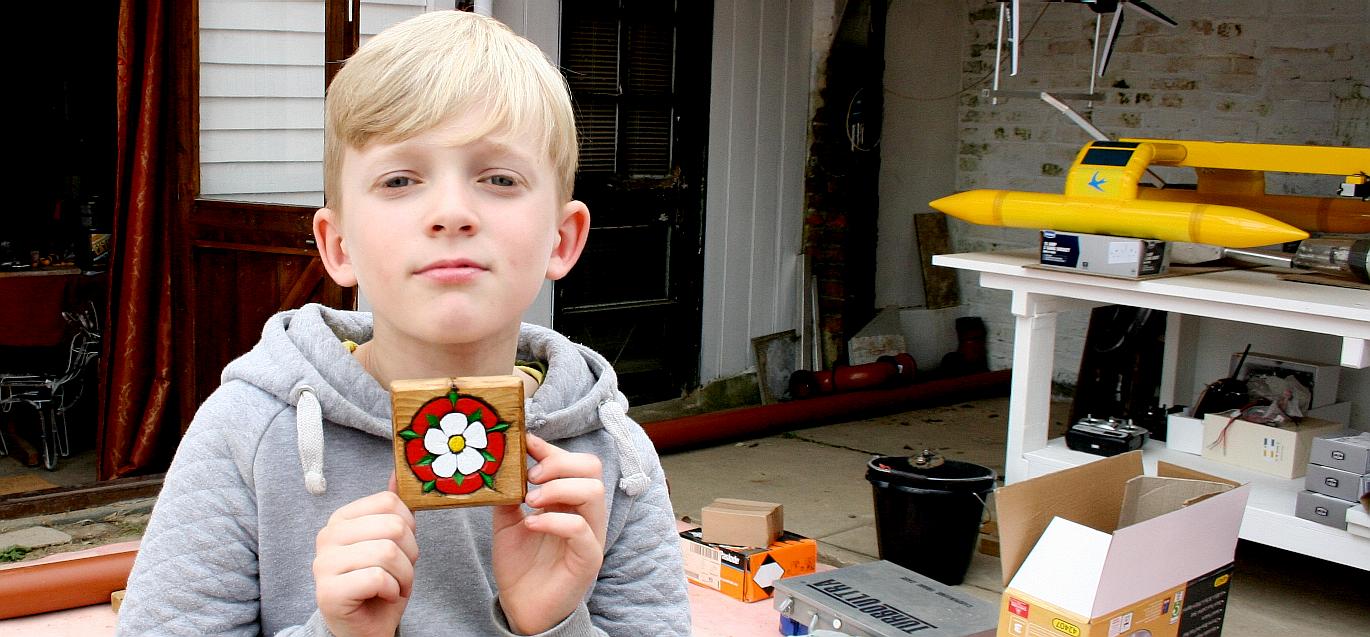 Ryan learns how to carve a rose in wood and then paint his homework