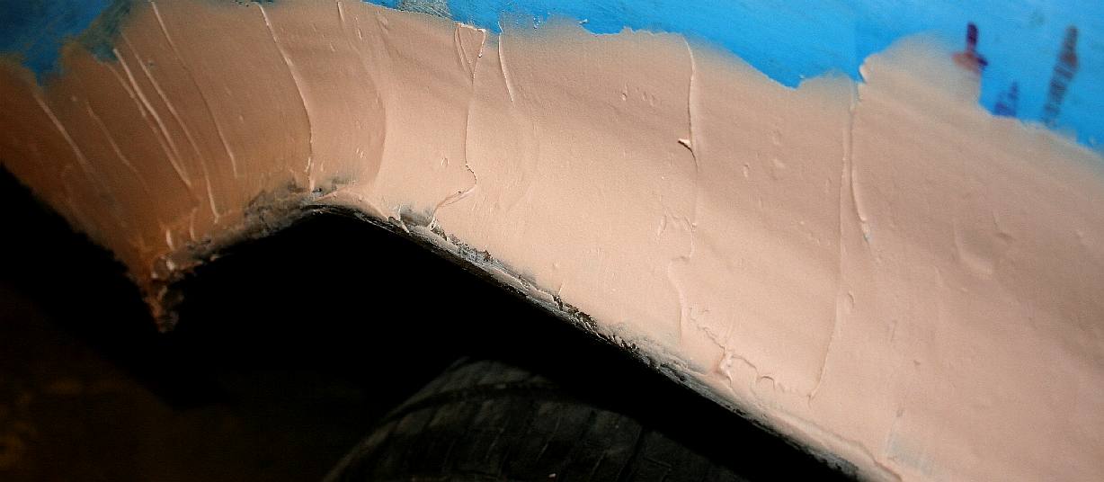 Applying polyester body filler paste to our custom wheel arches